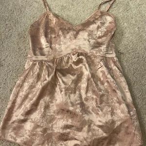 Rosa glansig topp med öppen rygg  - Superfin topp med öppen rygg. Det står inte märke eller storlek, men jag köpte den på plick och den är i superskick. Jag är vanligtvis XS/S och den passar mig. Bara att höra av sig om man har frågor.