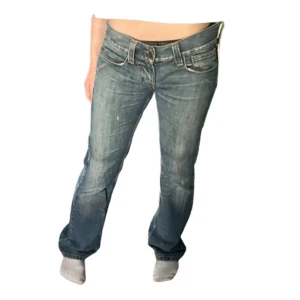 Blåa Lågmidjade bootcut jeans - Blåa Lågmidjade bootcut jeans från märket Fornarina, märkta Stl 30 vilket jag uppskattar till M/L. Midjemått: Ca 43cm rakt över och Innerbenslängd: 84cm. Jag på bilden är 172cm men skulle säga att de är aningen långa på mig. Är lite slitna längst ner vid benen men inget märkvärdigt❗️💕 Säljer pga av att dem är för stora på mig. ❗️Lite blåare/ljusare i verkligheten än på bilderna ❗️Andra bilden på färgen är mest accurate❗️