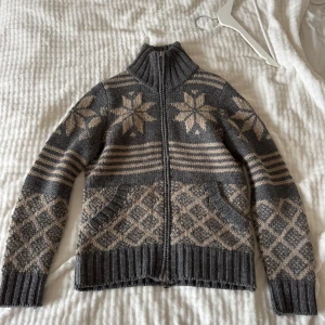 Grå stickad tröja från Moncler  - Säljer en grå stickad tröja från Moncler med dragkedja och hög krage. Tröjan är stilren och perfekt för kalla dagar när du vill vara både varm och stilren.