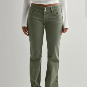 Gröna jeans - Snygga gröna lågmidjade jeans med bootcut-modell och broderade detaljer på bakfickorna. Jeansen är slutsålda och kostar 700kr nya. Säljer de för att de inte längre kommer till användning.