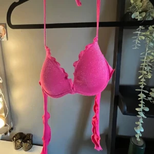 Glittrig rosa bikini med volang - Snygg rosa bikini med glittrigt tyg och volangdetaljer längs kanterna, aldrig använd från calzedonia 🩷🩷🩷