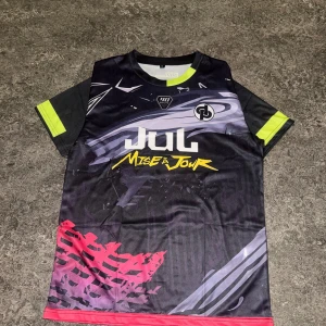 Svart fotbollströja Jul x Don et de Platine - Cool fotbollströja i svart med grafiskt mönster, detaljer i neon-gult och rött. Framsidan har tryck med 'Jul Mise à Jour' och logga, baksidan har 'Ninetta' och stor logga.