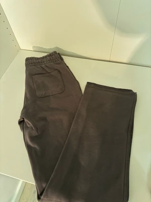 Mörkgrå mjukisbyxor med snörning - Säljer ett par mörkgrå mjukisbyxor med resårmidja och snörning. Byxorna har två stora fickor fram och en bakficka. Perfekta för chill dagar eller när du vill vara extra bekväm. Tillverkade i mjukt bomullsmaterial. Ena benet är uppsprättat då jag ville se om de skulle passa min längd (korta på mig som är 175cm)🤎