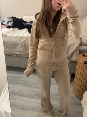 Beige juicy couture set - Säljer mitt juicy couture set i beige. Använt några gånger men är i bra skick, byxorna är i XXS och tröjan är i S. Det är fickor på rumpan på byxorna. Är en fläk på båda ben längst ner men det syns men inte så jättemycket.