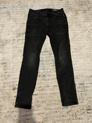 Replay anbass hyperflex - Snygga svarta slim jeans med smal passform och klassisk femficksdesign. Jeansen har en mörk tvätt och raka ben, perfekta för en stilren look. Tillverkade i stretchigt jeanstyg för extra komfort.