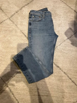Blå raka jeans från Jack & Jones - Snygga blå jeans från Jack & Jones i klassisk rak modell. Jeansen har fem fickor, normal passform och är tillverkade i mjukt bomullsdenim. Perfekta till en avslappnad stil och funkar året runt.