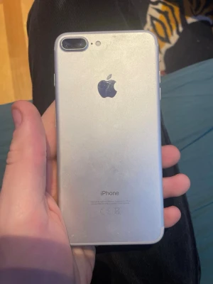 Silverfärgad iPhone 7 Plus - Säljer en silverfärgad iPhone 7 Plus, Telefonen har en stilren aluminiumdesign och stor skärm. Den funkar utmärkt som första telefon till barn eller som present, Funkar även att spela spel på den, och batteriet håller länge tack vare sin batterihälsa på hela 87%.  Men bra att veta är att det finns nån defekt i kameran så den laddar in bakre kamerorna väldigt sent, ibland måste man stänga kameraappen och starta appen igen, men för övrigt är den i väldigt bra skick, vill ha 679kr för den. 