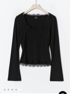 Svart långärmad topp med spets - Svart långärmad topp med rund halsringning och fina spetsdetaljer vid halsen och nederkanten. Figurnära passform som ger en snygg siluett. Perfekt att styla med jeans eller kjol. Aldrig använd🥰🫶🏻