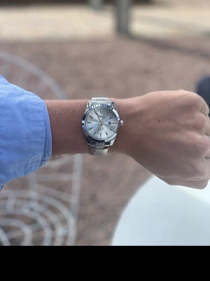 Silverfärgad klocka från Doventi  - Stilren klocka från Doventi med silverfärgad urtavla och länkarmband i metall. Klockan har datumvisning och klassisk design med tydliga indexmarkeringar. Perfekt accessoar för en clean look.