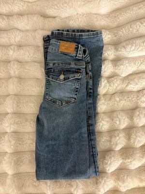 Blå jeans från Gina tricot, stl 32 - Snygga blå jeans från Perfect Jeans i klassisk femficksmodell. Jeansen har normal passform, dragkedja och knapp framtill samt detaljerade sömmar och en ljus tvätt. Perfekta för en avslappnad och trendig look.