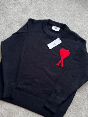 Svart stickad tröja från Ami Paris - AMI Paris tröja – helt ny. Oanvänd och i nyskick. Klassisk design med den ikoniska AMI-loggan. Strl S men passar mer som M Skickas supersnabbt 📦 Skriv vid frågor!