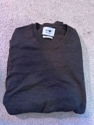 Olivfärgad Crewneck ifrån N007 - Riktigt snygg långärmad tröja ifrån N007. Storlek S. Material, Merinoull. Finns en defekt i vid vänstra ärmen, ett litet hål som knappt syns, framför allt inte om du har uppkavlade ärmar. Hör av dig om du vill ha bild på de. 