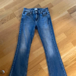 Blå bootcut jeans - Säljer ett par blå bootcut jeans från ONLY i storlek 28/S och det är petite storlek. De sitter relativt låg midjat på mig. Jag är 155cm och de passar mig perfekt! 