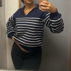 Marinblå randig tröja & Other Stories - Säljer en marinblå tröja från & Other Stories med vita horisontella ränder. Tröjan har v-ringning med krage och långa ärmar. Perfekt för dig som gillar en klassisk och chill stil. Materialet är mjukt och känns skönt mot huden.