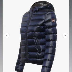 Mörkblå dunjacka från Colmar - Snygg mörkblå dunjacka från Colmar med glansig finish och huva. Jackan har quiltad design, dragkedja framtill och två fickor med dragkedja.  