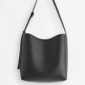 Stor axelremsväska  - ALDRIG ANVÄND! Stilsäker stor axelremsväska i läderimitation. Väskan har ett brett axelband, magnetstängning och en löstagbar mindre väska med dragkedja på insidan. Ett fack Brett justerbart axelband Magnetisk stängning Liten löstagbar väska med dragkedja på insidan Läderimitation Mått ca 36 x 29 x 12 cm