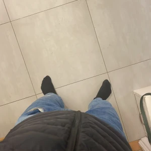 Svart väst från Dressmann - Säljer en svart väst från Dressmann med horisontella sömmar och dragkedja framtill. Jackan är lätt vadderad och har en stilren look som passar perfekt till kyligare dagar. Enkel och snygg design utan krusiduller. Storlek: L. Rekommenderas att ha något varmt under, för att sitta tajt. Håller värme bra! Ett jätte pyttelitet hål på framsidan.