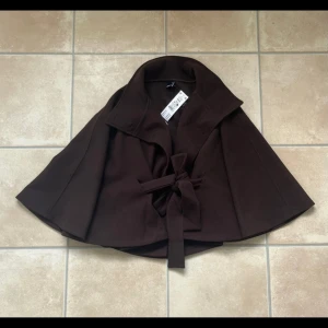 Cape jacket Gina tricot - Snygg mörkbrun poncho jacka från Gina tricot. Endast testad! Helt slutsåld storlek xs/s