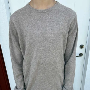 Beige kashmirtröja från Davida - Mjuk och stilren beige tröja från Davida i kashmir. Andvänd ett fåtal gånger. Klassisk rund halsringning och långärmad modell, perfekt för lager-på-lager. Enkel design som är lätt att matcha med olika outfits.