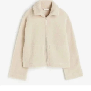 Beige teddyjacka med dragkedja - Mysig beige teddyjacka med krage och hel dragkedja framtill. Jackan har två stora fickor och är långärmad med en loose passform. Perfekt för att hålla sig varm och samtidigt se chill ut.