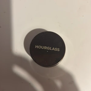 Hourglass Scattered Light Glitter Eyeshadow - Hourglass Scattered Light Glitter Eyeshadow i nyansen Ray. En krämig ögonskugga med intensivt skimmer i en varm, bronsig ton. Kommer i en rund, transparent burk med metallock. Perfekt för att skapa en glittrig look med mycket lyster.
