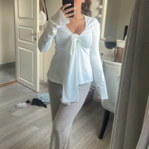 Vit omlottopp med knyt från SHEIN - Säljer en vit tröja från SHEIN i storlek S. Toppen har lång ärm, v-ringning och snygg knytning framtill. Materialet är mjuk, perfekt för dig som gillar stilrena och trendiga plagg.