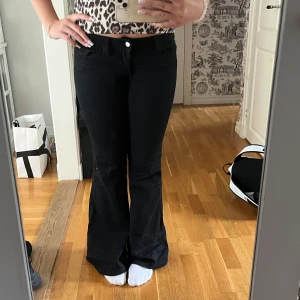 Svarta bootcut jeans - Säljer ett par svarta jeans med bootcut-modell och normal passform. Även med låg midja. Knapp och dragkedja framtill. Snygga till sneakers eller boots och passar perfekt till crop tops. Är från weekday och är i storlek 30/32.