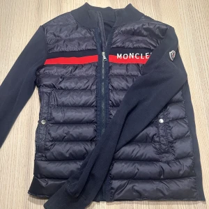 Moncler Cardigan - Säljer nu min gamla cardigan då den blivit alldeles för liten. Köpt på NK 2019 för 8400kr och använd sparsamt i 2 veckor. Skicket är alltså som nytt. Storleken är 164 i ungdom så passar dig mellan 160 och 170. Finns på Värmdö men kan fraktas