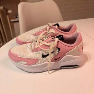 Säljer ett par snygga Nike Air Max sneakers i rosa och vit. De har en bekväm passform med snörning och en luftig mesh-ovandel. Perfekta för både vardag och träning. Sulan är i bra skick och ger bra dämpning. Passa på att köpa dessa stiliga skor! De är i storleken 36 och är använda men tvättade!