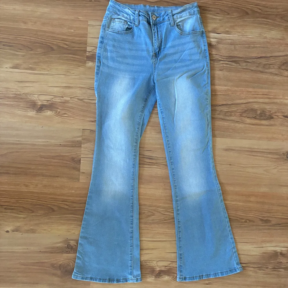 Säljer ett par ljusblå bootcut/flared jeans i bra skick. De är perfekta för både vardag och fest. Jeansen har en snygg utsvängd stil. De har blivit använda max två gånger!. Jeans & Byxor.