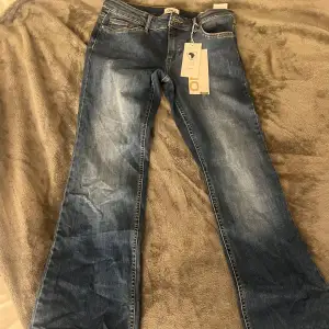 Säljer ett par snygga blå jeans från Only. Jeansen är i bootcut-stil och low waist. Har aldrig används och prislappen kvar. Måtten är 37 i midjan och innerben 77 men de står L/34 men skulle säga att den är en s-m