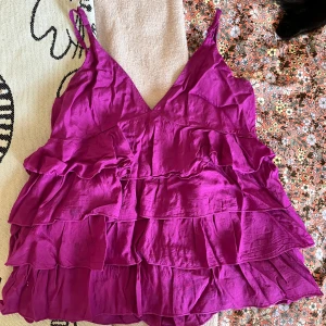 Volangtopp - Så fin volangtopp i en mörkrosa färg!💕 Storleken enligt lappen är 44 men skulle säga att den passar allt mellan S-L! Axelbanden är skjuserbara!