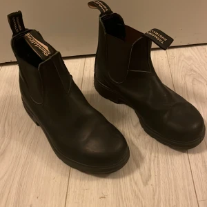  Blundstone barnsko stl 34  - Säljer ett par klassiska svarta Blundstone boots. De är tillverkade i slitstarkt skinn och har en robust sula för bra grepp. Perfekta för både stad och natur. Stl 34 (22,7 cm innermått)