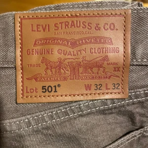 Bruna Levis 501 jeans - Säljer ett par klassiska brun/beiga Levis 501 jeans i storlek W32 L32. Dessa jeans har en rak passform och är tillverkade i slitstarkt denim. I princip oanvända!