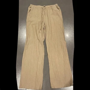 Beige linnebyxor från Gina Tricot - Säljer ett par beige linnebyxor från Gina Tricot. Byxorna har en loose passform med elastisk midja. Skriv för mer bilder eller andra frågor :) 