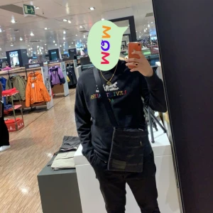 Svart hoodie från Levi's och Calvin Klein Axelremsväska - Säljer en stilren svart hoodie från Levi's med färgglatt tryck på bröstet. Perfekt för en avslappnad look. Hoodien har en klassisk passform. 500 kr tröjan och 300kr väskan 