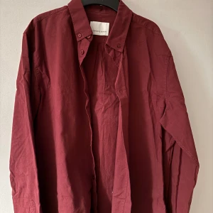 Vinröd skjorta från Samsøe Samsøe - Snygg vinröd skjorta från Samsøe Samsøe i storlek M. Skjortan har långa ärmar och knappar framtill. Perfekt för en stilren look.