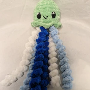 Grön virkad manet - En söt grön virkad manet med blå och vita tentakler. Den är gjord av 100% polyester. 