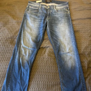 Blå jeans från Replay - Säljer ett par snygga blå jeans från Replay, modell Grover. De har en straight fit med storlek 34,34 och klassisk femficksdesign med knappgylf. Perfekta för en avslappnad stil. Jeansen är använda men utan skador och defekter. Den är även lite mörkare i verkligheten än på bild. 