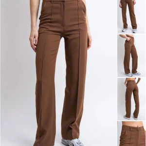 Kostymbyxor - Snygga bruna byxor från Madlady med hög midja och raka ben. Perfekta för en stilren look. Byxorna har en klassisk design med fickor och dragkedja. Ena fickan har ett litet hål på insidan, men är inget som syns på utsidan!  Byxorna är i stl 34/32 och passar mig som är 168cm men även kortare