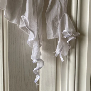 Mesh topp  - Vit mesh topp med volanger som tyvärr har ett band som är slitet (bild 2) men annars fin! 