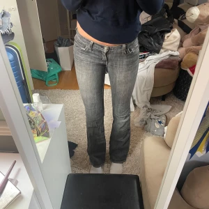 Grå bootcut jeans - Snygga grå bootcut jeans med låg midja. Perfekta för en avslappnad stil. Klassisk femficksdesign och dragkedja. Jag är 175cm.