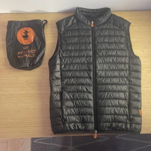 Svart dunväst från Save the Duck - Säljer en svart dunväst från Save the Duck. Säljer pågrund av att den e för liten, skick 8,5/10 skriv vid fler frågor eller bilder