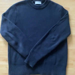Mörkblå crewneck Selected Homme - Säljer en stilren mörkblå stickad tröja från Selected Homme. Tröjan har långa ärmar och ribbade muddar vid ärmslut och nederkant, perfekt för kyligare dagar. Väldigt fint skick använd enstaka gånger inga defekter riktigt snygg