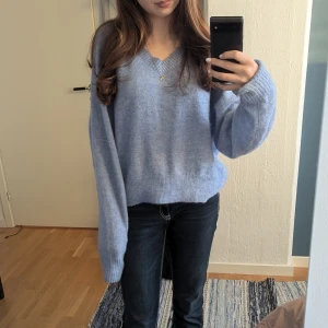 Ljusblå stickad tröja från Cubus - Mysig ljusblå stickad tröja från Cubus med v-ringning. Den är finstiskad av bland annat alpacaull och ull villket gör den hållbar och luftig men varm. Sitter så fint på men säljer för att jag är väldig känslig för material och tycker den är lite stixig.
