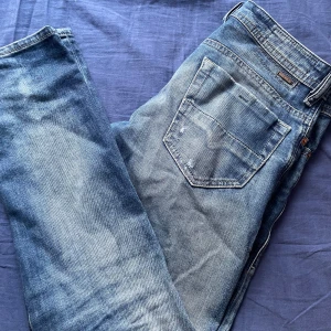 Blå jeans från Diesel - Tja! Jag säljer ett par Snygga blå jeans från Diesel i modellen Thommer. De har en slim passform och är tillverkade i jeansmaterial. Byxorna har snygga slitningar och är i storlek 30/30. Om du har några frågor tveka inte på att höra av dig!