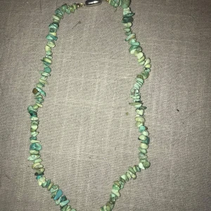 Grönt/ turkost halsband med stenar - Unikt halsband med gröna stenar i olika nyanser. Perfekt för att ge en naturlig touch till din stil. Stängs med ett enkelt spänne.