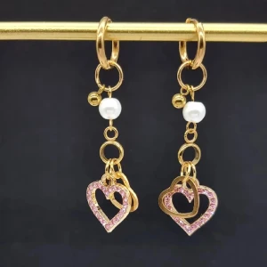 Guldörhängen med hjärtan och pärlor - Eleganta guldörhängen med hängande hjärtan dekorerade med rosa stenar och vita pärlor. Perfekta för att ge en romantisk touch till din stil.Handgjorda örhängen 🖤Gjord i bra kvalitet 💎●Material-100% rostfritt ,zinklegeringar och  glas pärlor●Örhängeskrokar -rostfritt stål. Nickel fri. Längd -6cm 