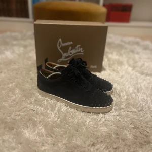 Christian Louboutin mörkblå - Säljer ett par marinblå sneakers från Christian Louboutin. Skorna är i väldigt fint skick men har en liten defekt på insidan som inte syns när dom sitter på. Skorna är i storlek 44 men sitter en aning större. Box, dustbags och kvitto medföljer. Skorna är lite smutsiga för tillfället men om du vill tvättar vi skorna innan frakt. Kan gå ner i pris vid snabb affär. Hör av dig vid frågor!