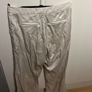 Vita kostymbyxor - Snygga vita kostymbyxor med en klassisk design. Byxorna har fickor både fram och bak, vilket ger en stilren look. Perfekta för en elegant och stilfull outfit. Sitter så snyggt på!!